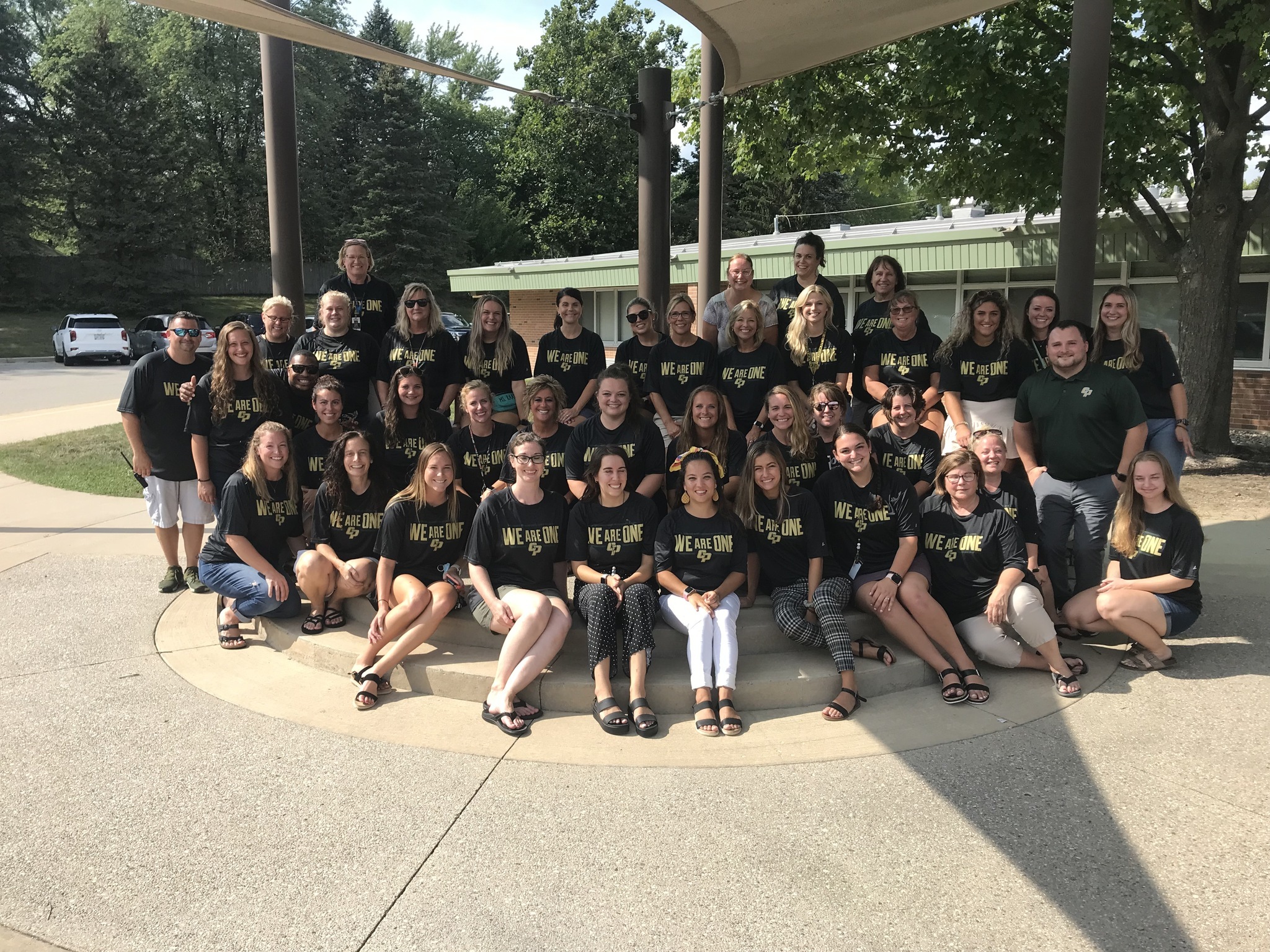 Staff Picture in We Are One shirts behind Stoney Creek Elementary School